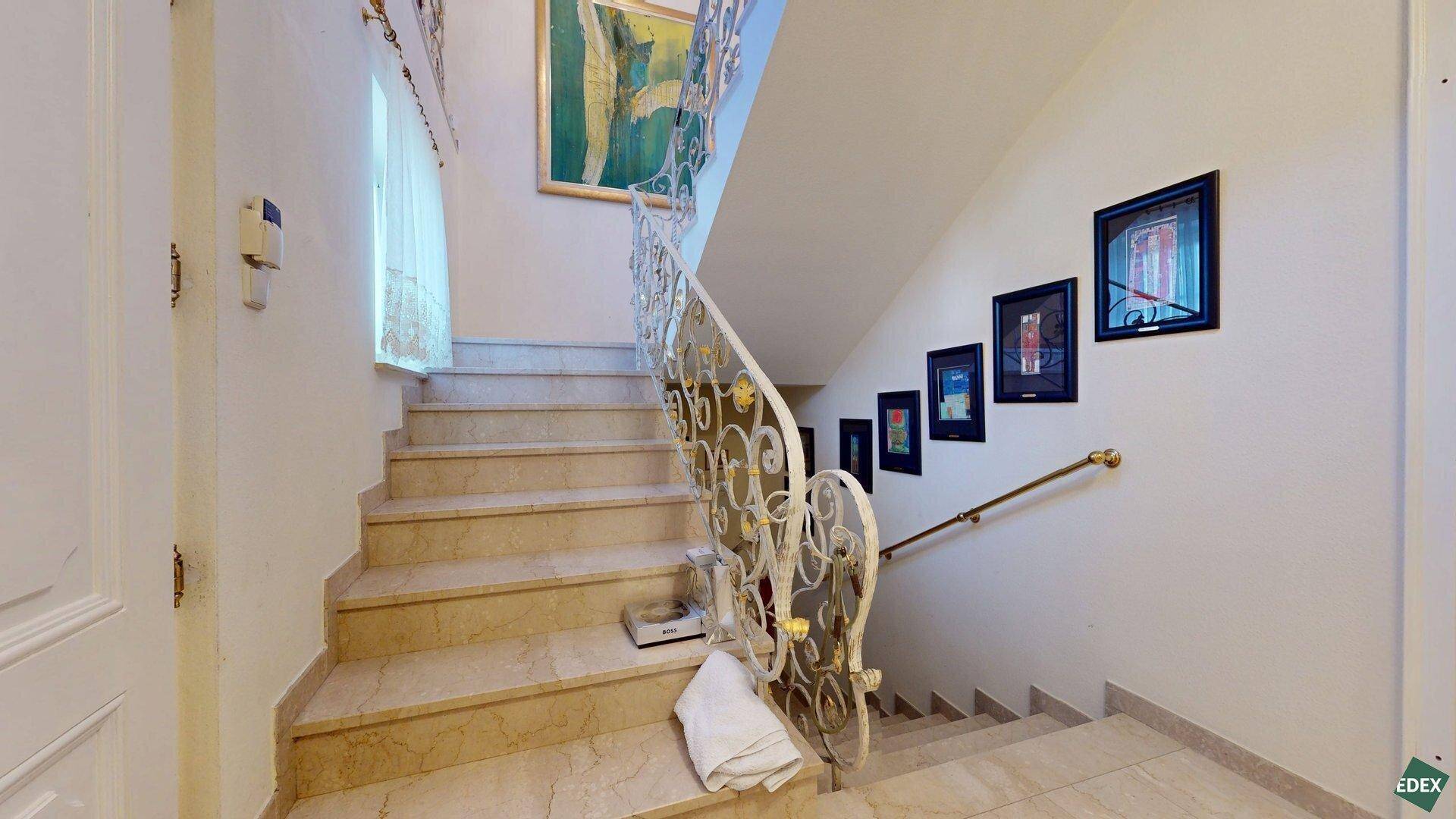 Elegante Marmortreppe mit kunstvoll geschmiedetem Geländer, die in die oberen Stockwerke führt.