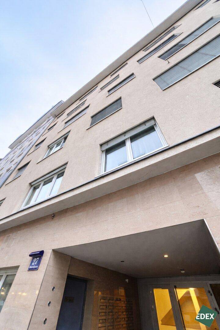 Moderne Gebäudefassade mit mehreren Fenstern und einem einladenden Eingangsbereich.