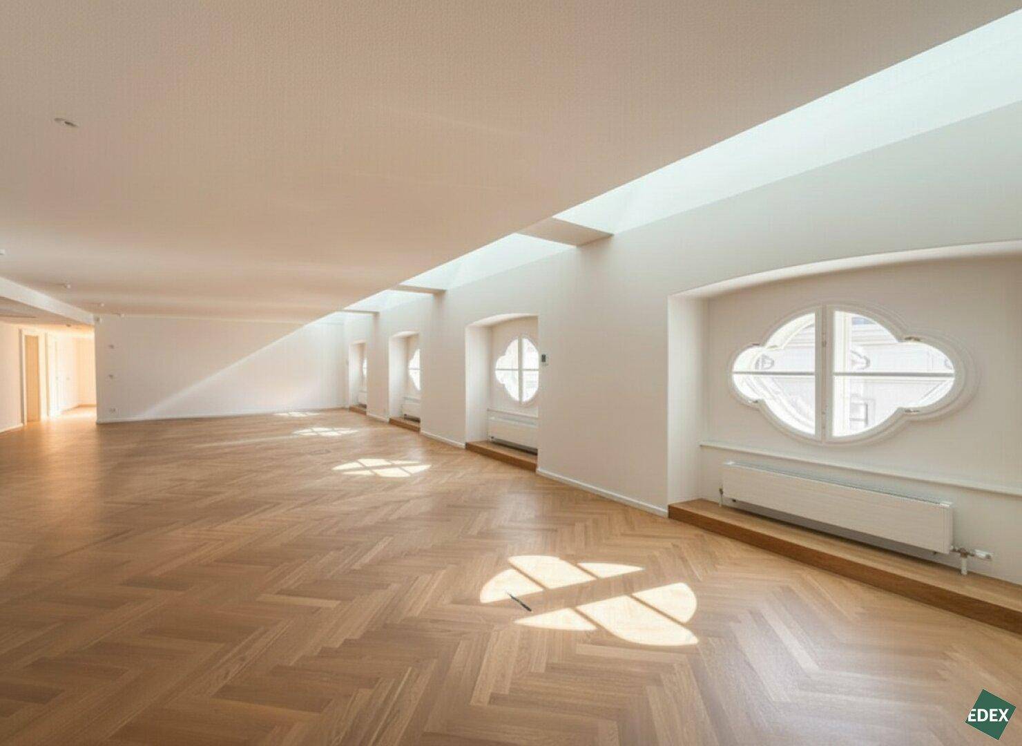 Heller Büroraum mit einzigartigen Fenstern, Fischgrätparkett und einem langen Oberlicht, das viel Tageslicht spendet.