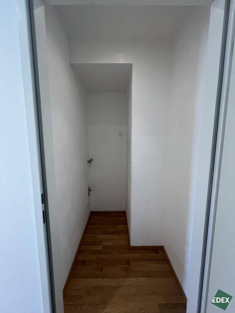 Praktischer Wirtschaftsraum mit Anschlüssen für Waschmaschine und Trockner, ideal für zusätzlichen Stauraum.