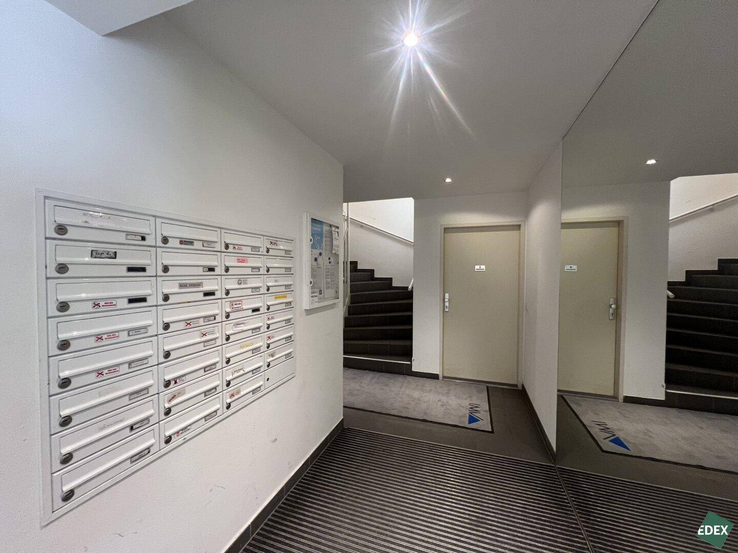 Eingangsbereich mit Briefkästen und Spiegelwand, führt zum Treppenhaus und den Wohnungen.