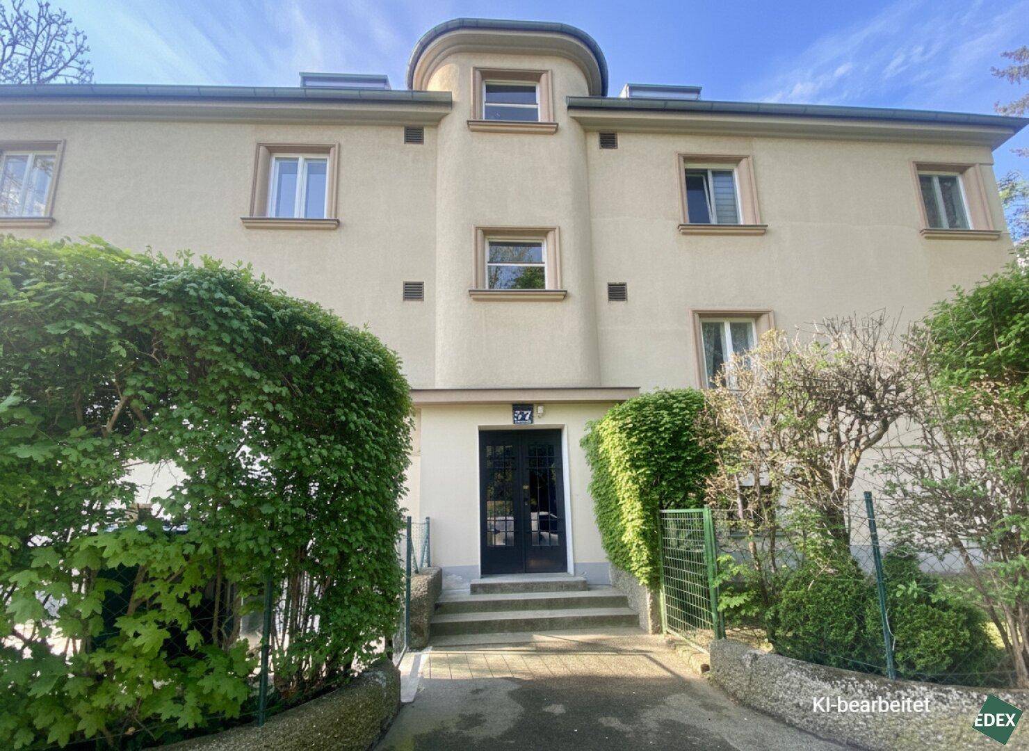 Attraktive Fassade eines Mehrfamilienhauses mit gepflegtem Eingangsbereich und Grünflächen.