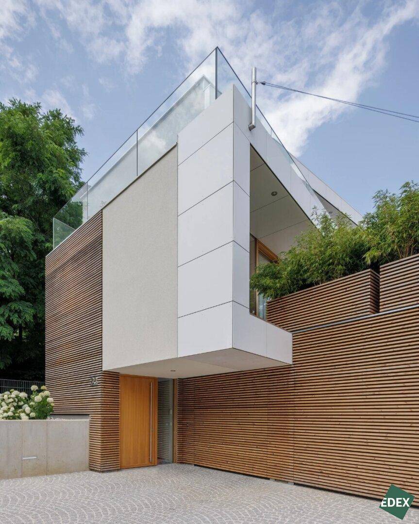 Moderner Eingangsbereich der Villa mit Holzlamellenfassade und minimalistischem Design.