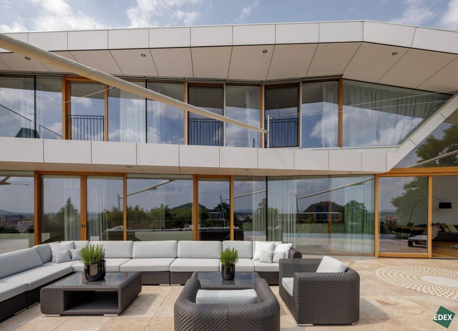 Große Terrasse mit bequemen Loungemöbeln und weitem Blick über die Landschaft.