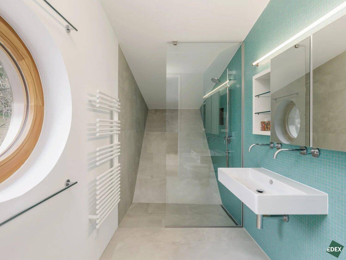 Helles Badezimmer mit ebenerdiger Dusche, modernem Waschbecken und beheiztem Handtuchhalter.