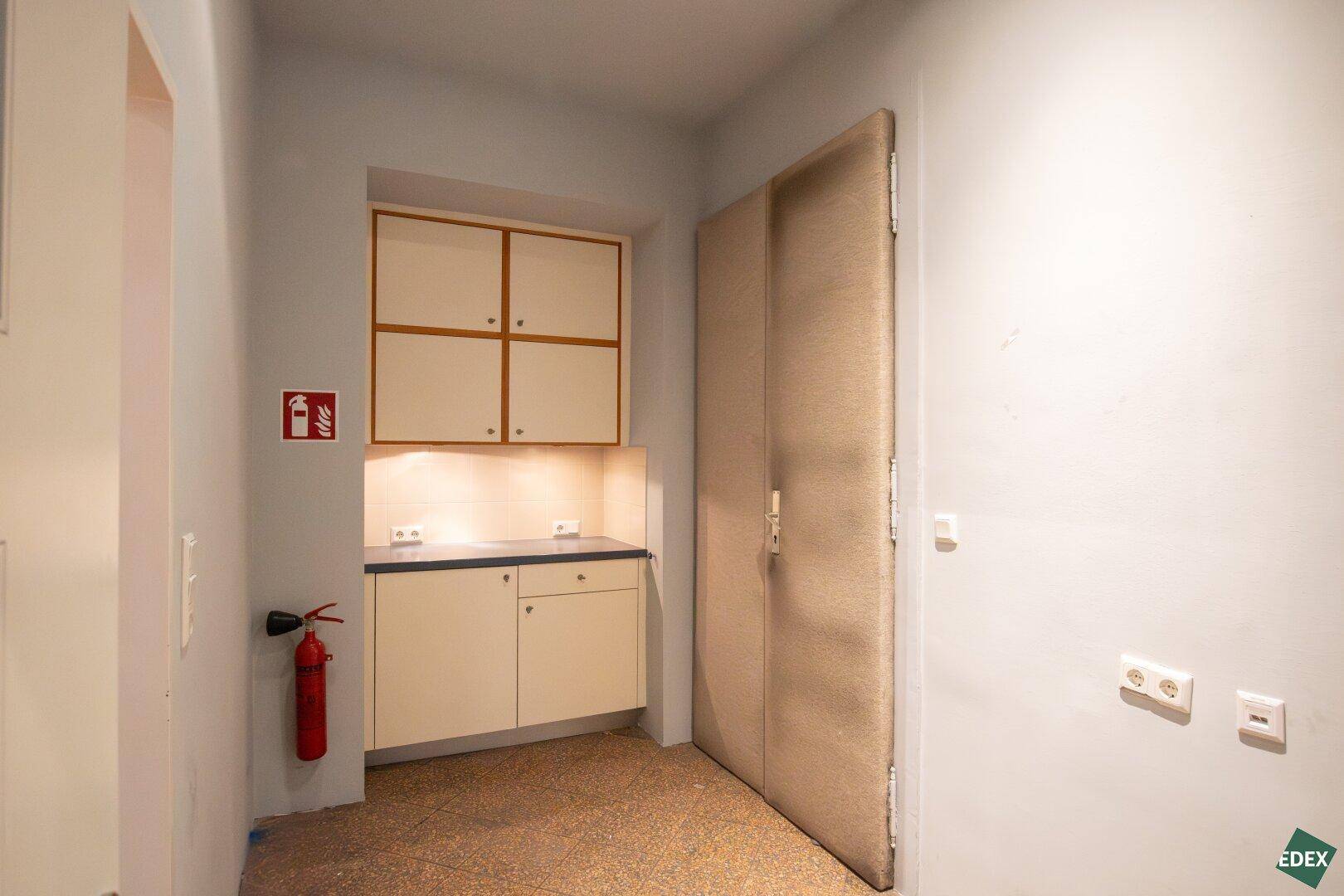 Flur mit Einbauschränken, Feuerlöscher und funktionaler Beleuchtung, ideal für zusätzlichen Stauraum.