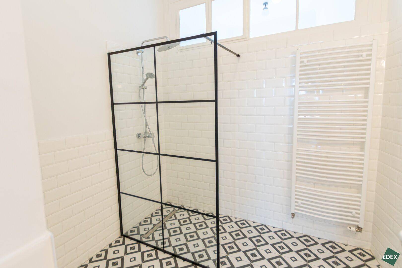 Modernes Badezimmer mit begehbarer Dusche, weißer Metrofliesenwand und beheiztem Handtuchhalter.
