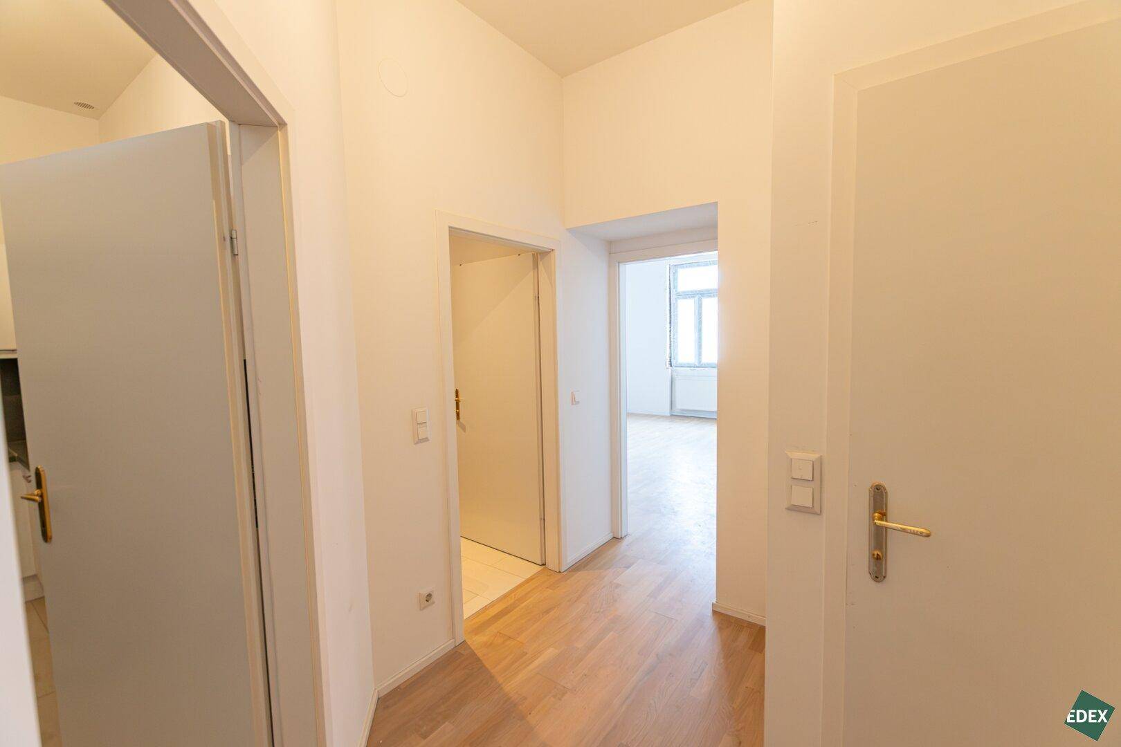 Heller Flur mit Parkettboden und Zugang zu verschiedenen Zimmern der Wohnung.