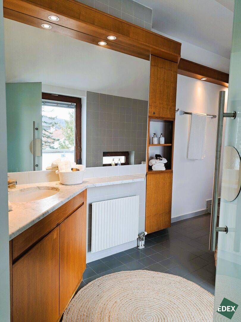 Modernes Badezimmer mit Doppelwaschbecken, Marmorplatte und Fenster.