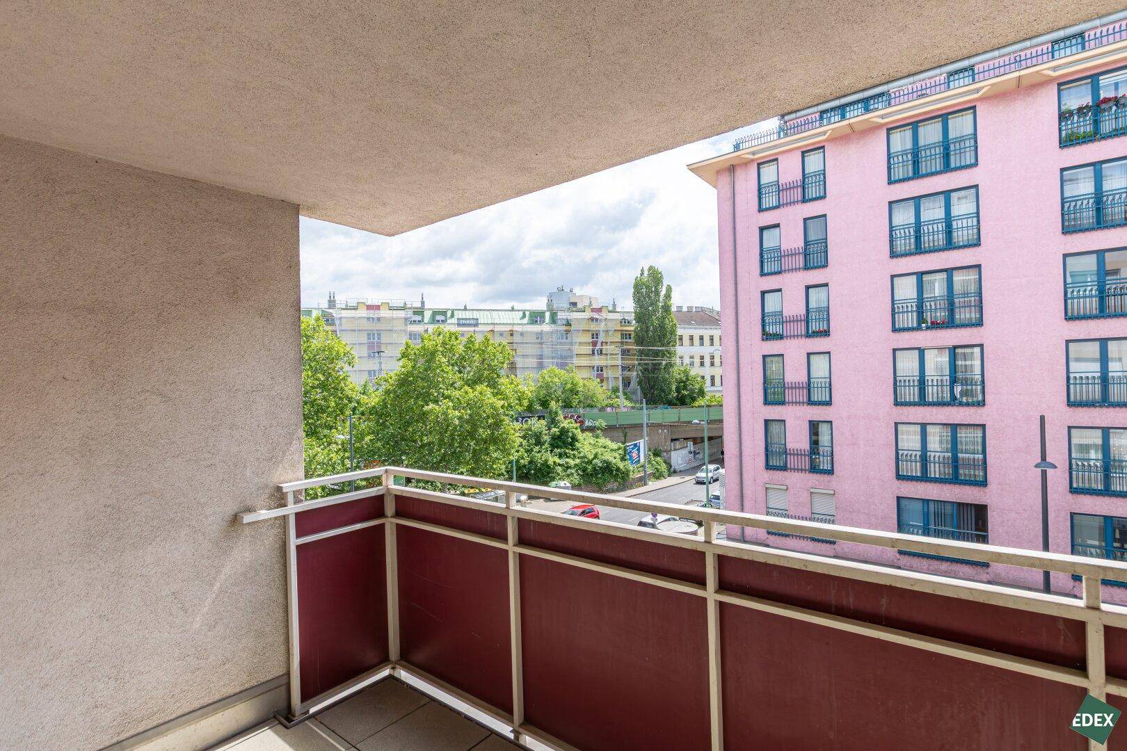 Balkon mit Blick auf die Straße und farbenfrohe Gebäude in der städtischen Umgebung.