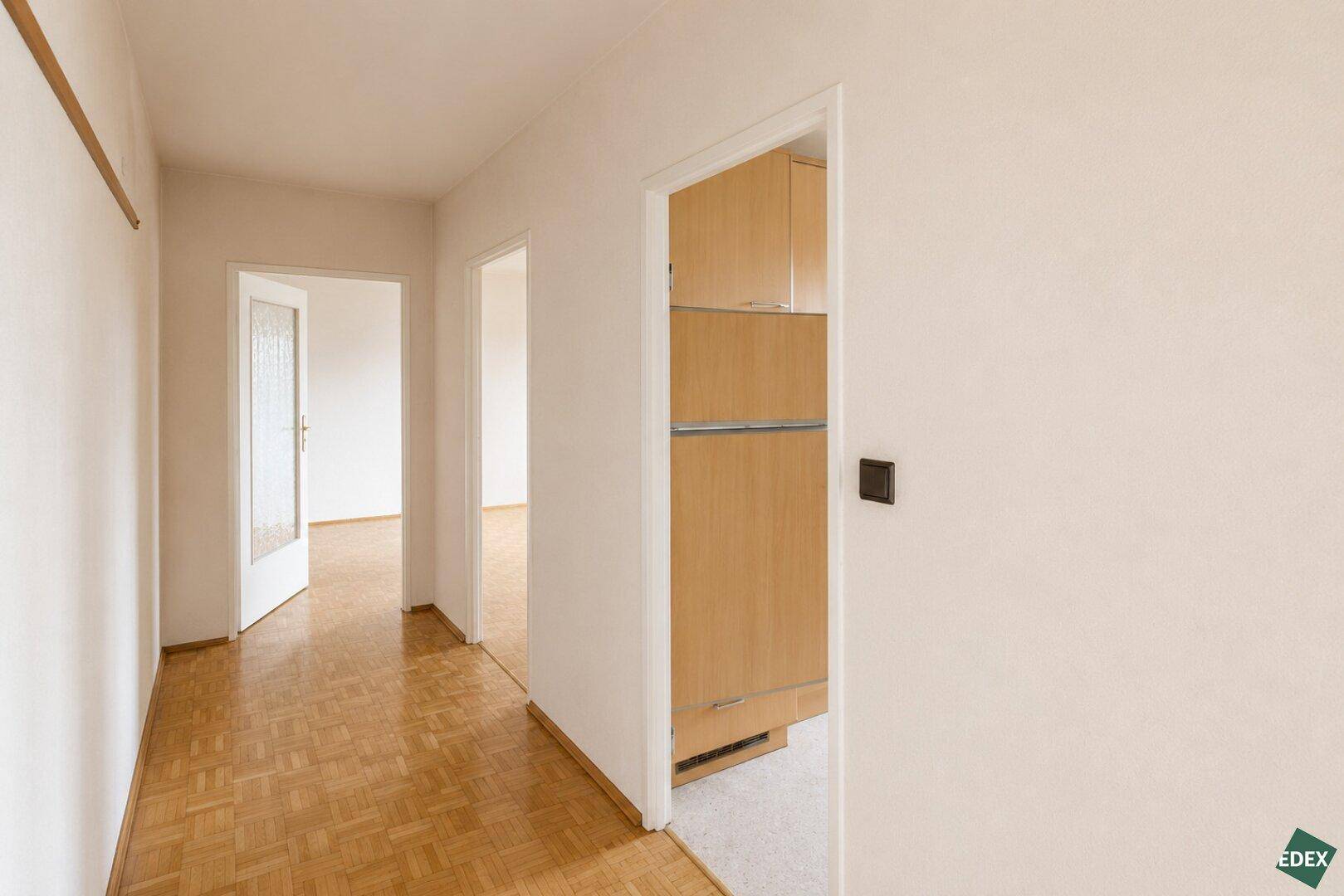 Heller Flur mit Parkettboden und offenen Türen zu den angrenzenden Zimmern.