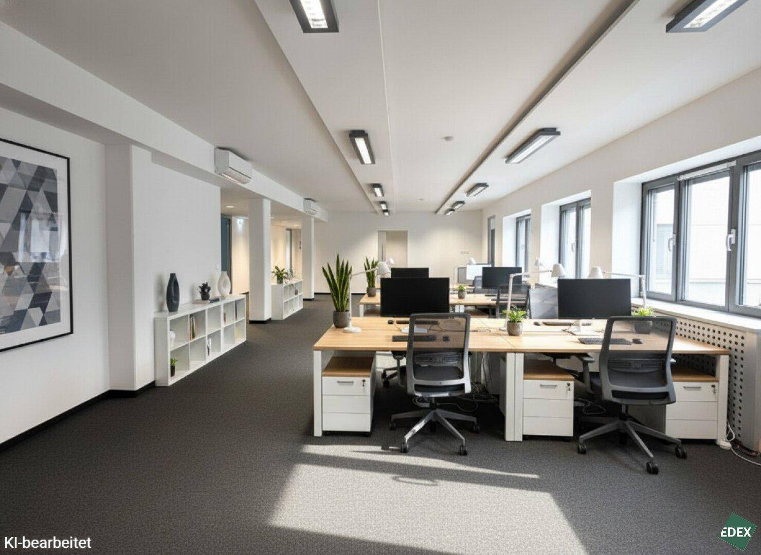 Möbliertes Großraumbüro mit Teppichboden, Schreibtischen und Pflanzen für eine angenehme Atmosphäre.