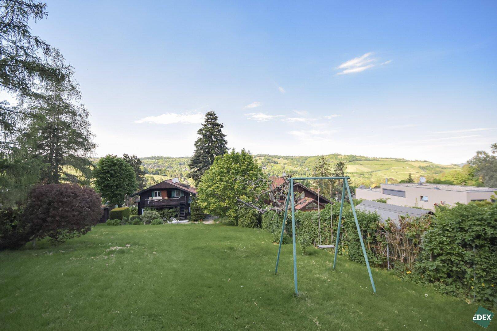 Großer Garten mit Rasenfläche, Schaukel und weitem Blick auf die Landschaft.