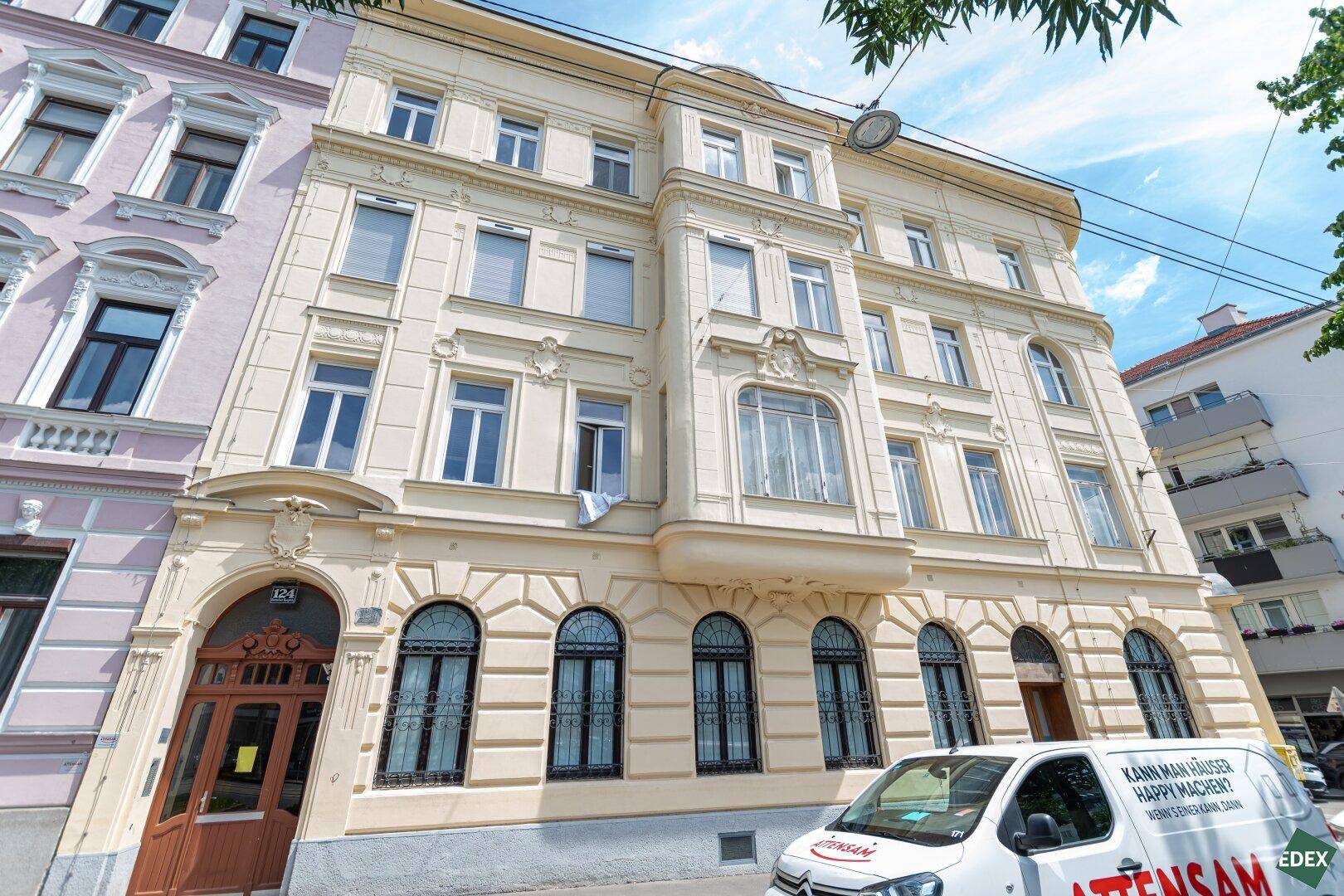 Klassisches Mehrfamilienhaus mit eleganter Fassade, vielen Fenstern und Balkonen.