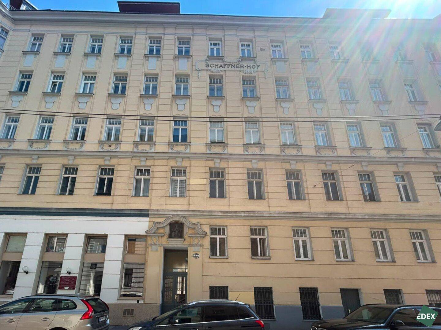 Historisches Mehrfamilienhaus mit klassischer Fassade und vielen Fenstern in städtischer Umgebung.