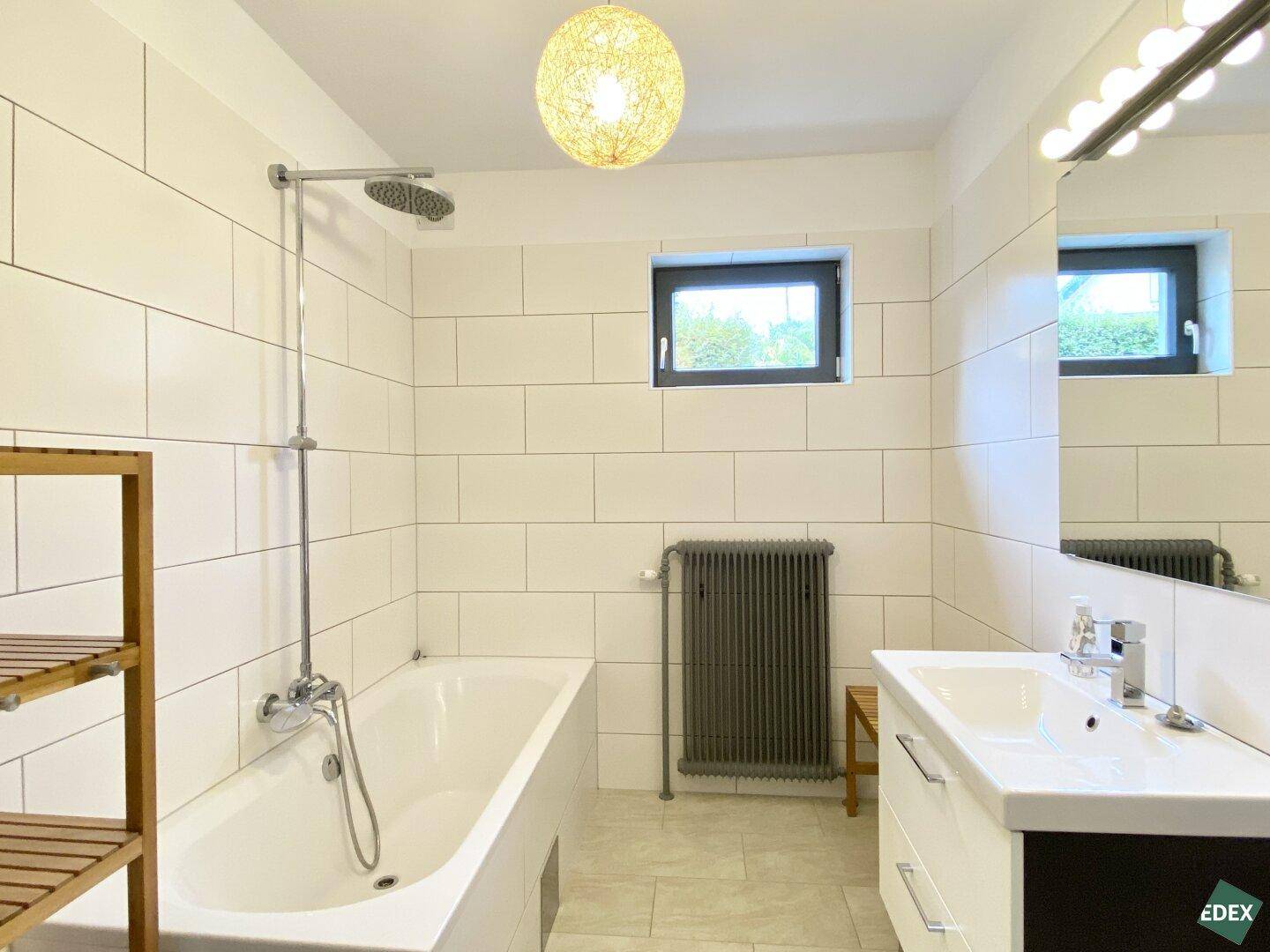 Modernes Badezimmer mit Badewanne, Dusche, Einzelwaschbecken und Fenster.