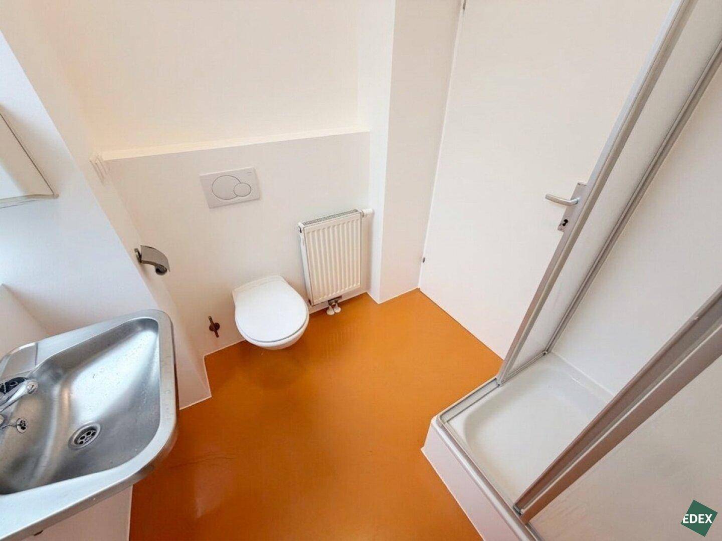 Modernes Badezimmer mit Dusche, WC und Waschbecken, in hellen Farben gehalten und gut gepflegt.