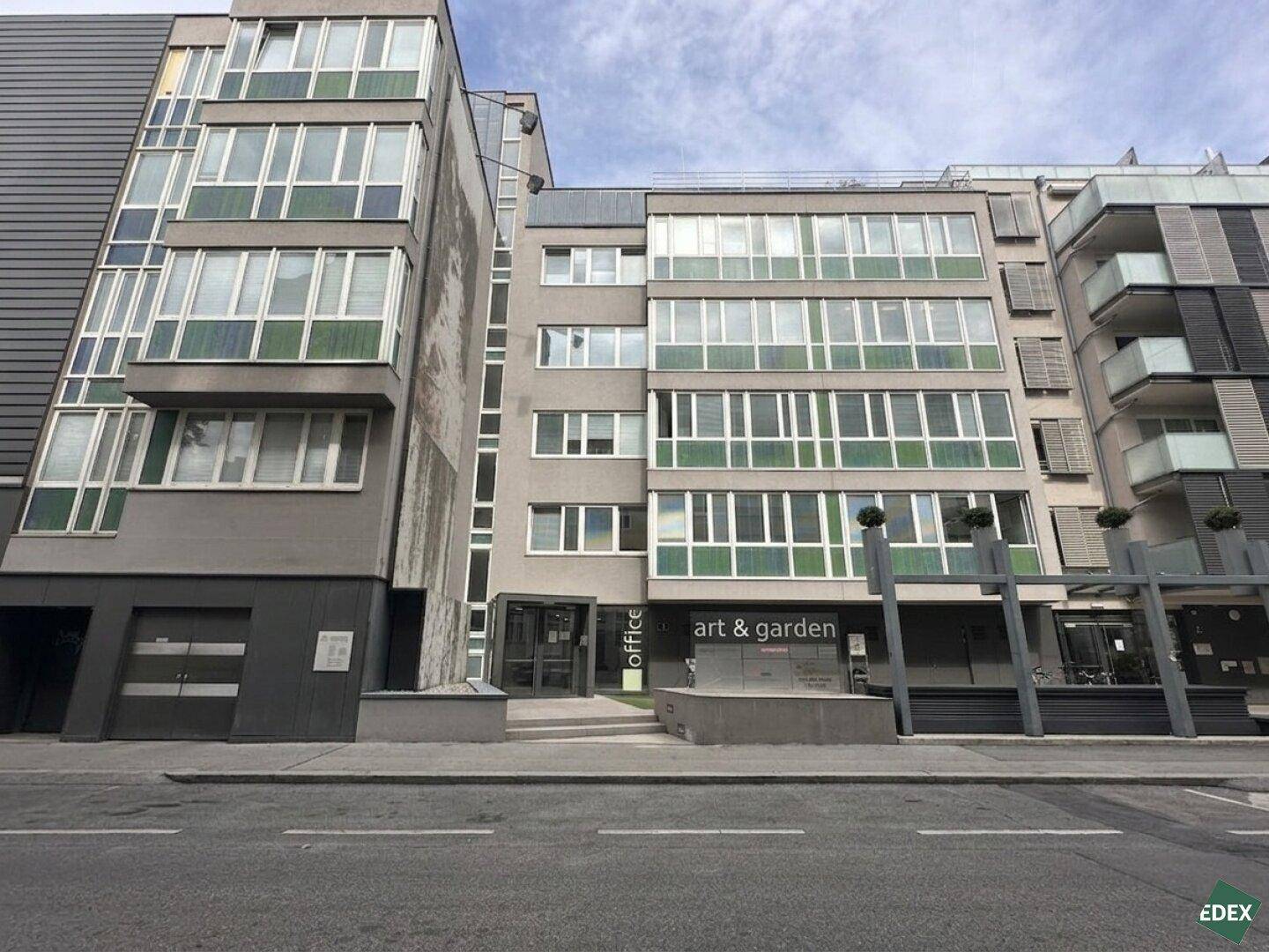 Fassade eines modernen Bürogebäudes mit Eingangsbereich und großen Fensterfronten.