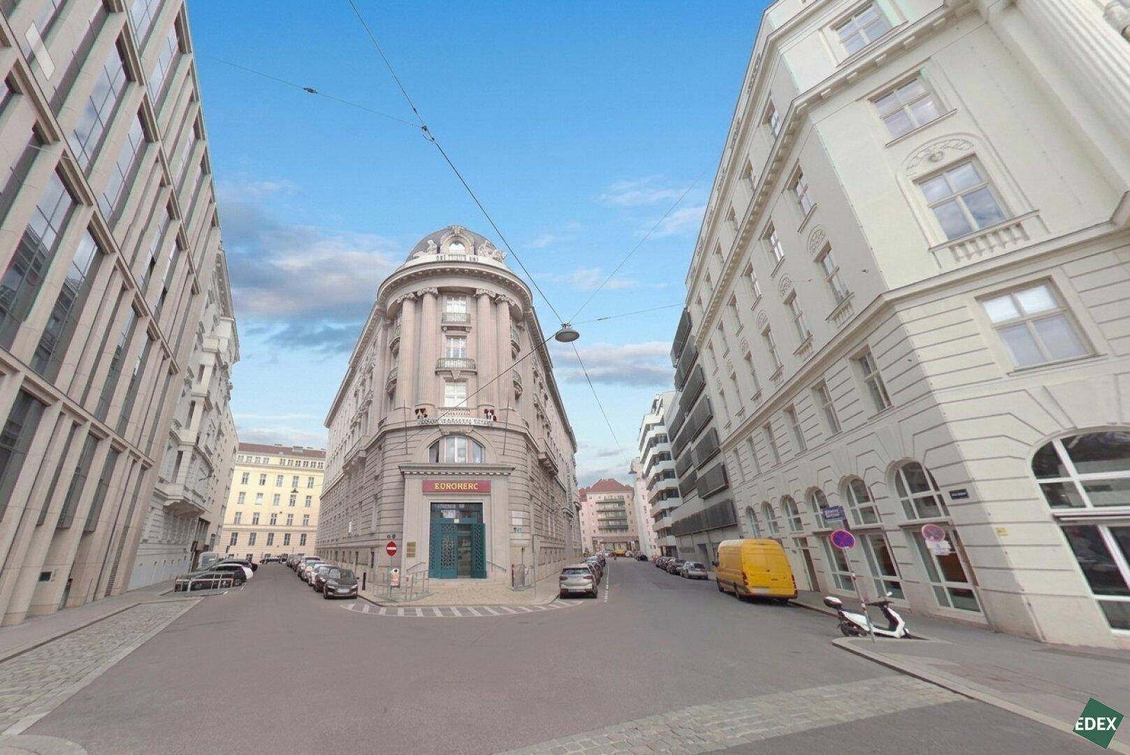 Historisches Gebäude an einer städtischen Kreuzung mit klassischer Architektur und umliegenden Gebäuden.