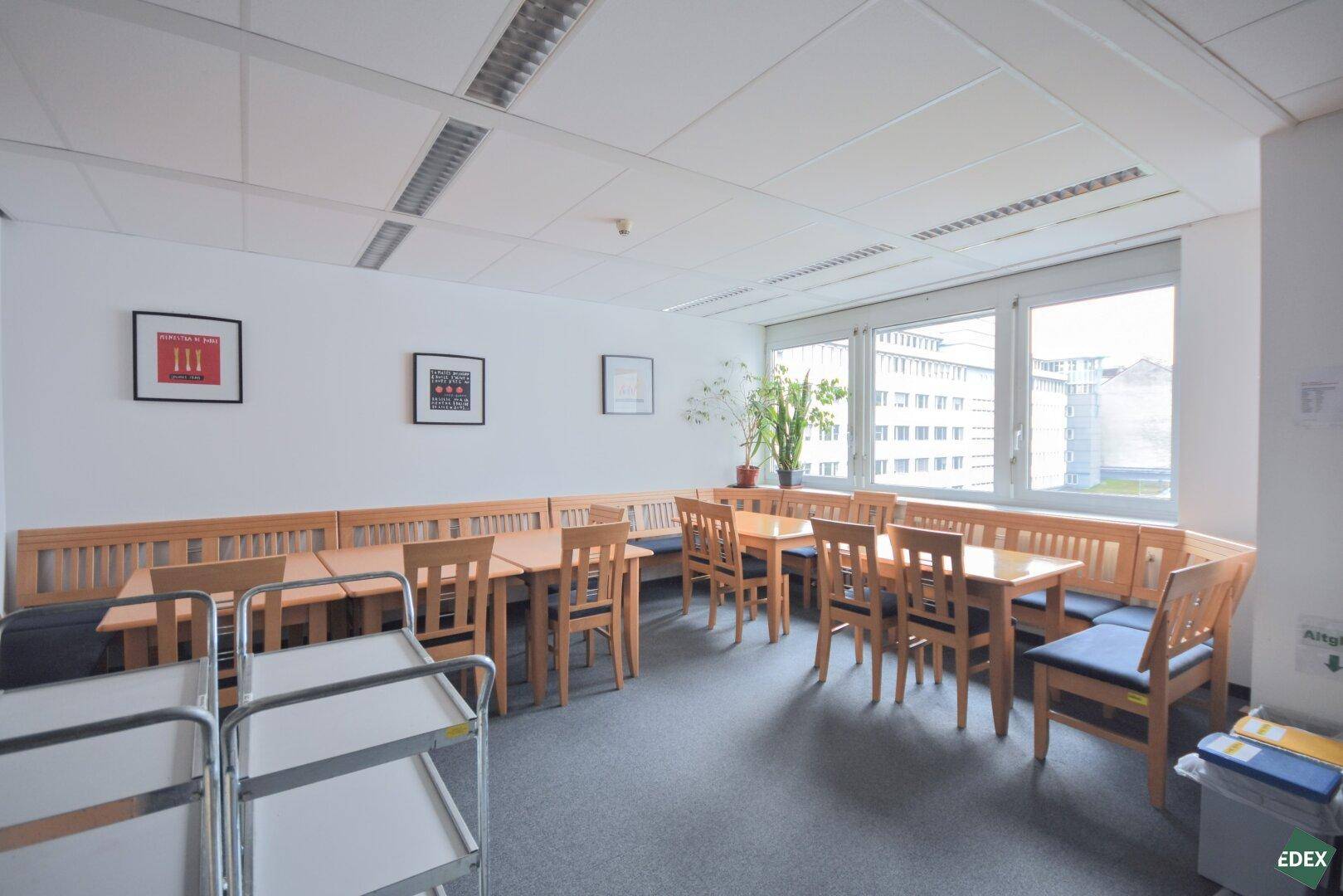 Geräumiger Essbereich mit Holztischen und Bänken, ideal für Pausen oder informelle Besprechungen.