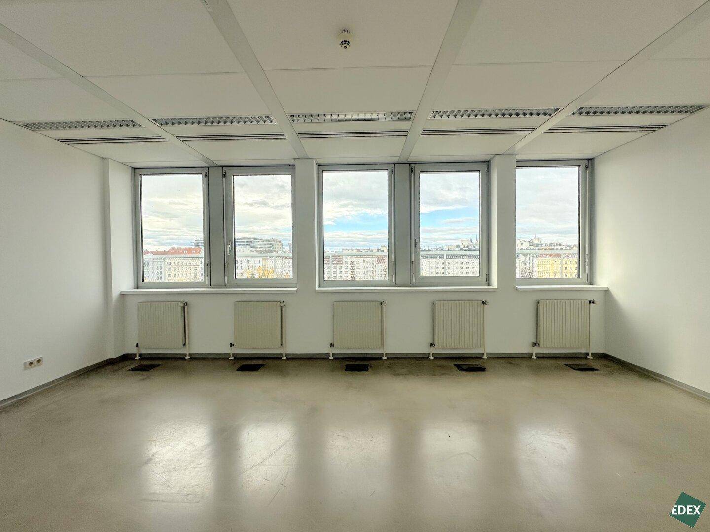 Geräumiger, heller Büroraum mit einer Fensterreihe, die einen weiten Blick ermöglicht.