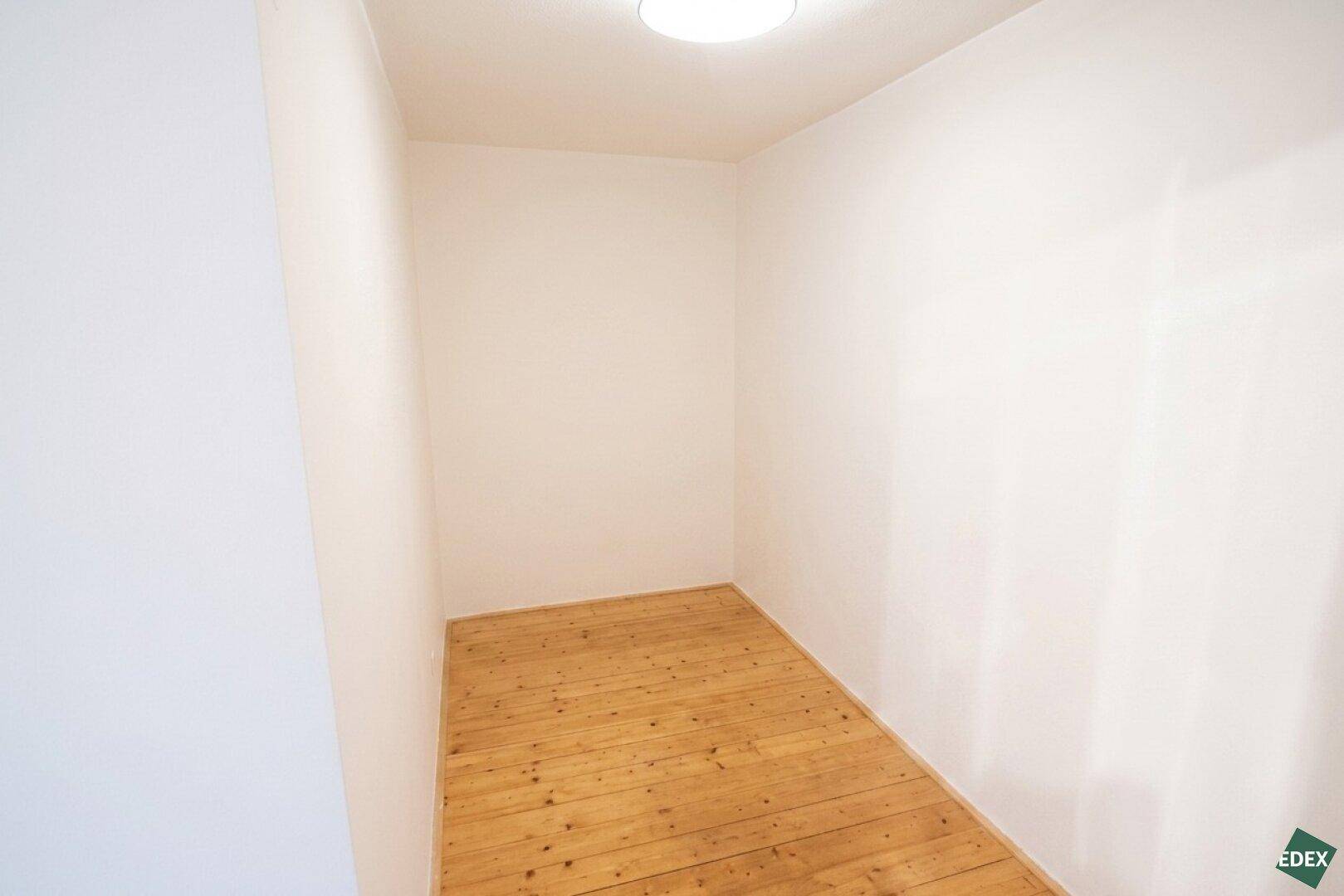 Kleiner, leerer Raum mit Holzdielenboden und weißen Wänden, ideal als Abstellraum nutzbar.