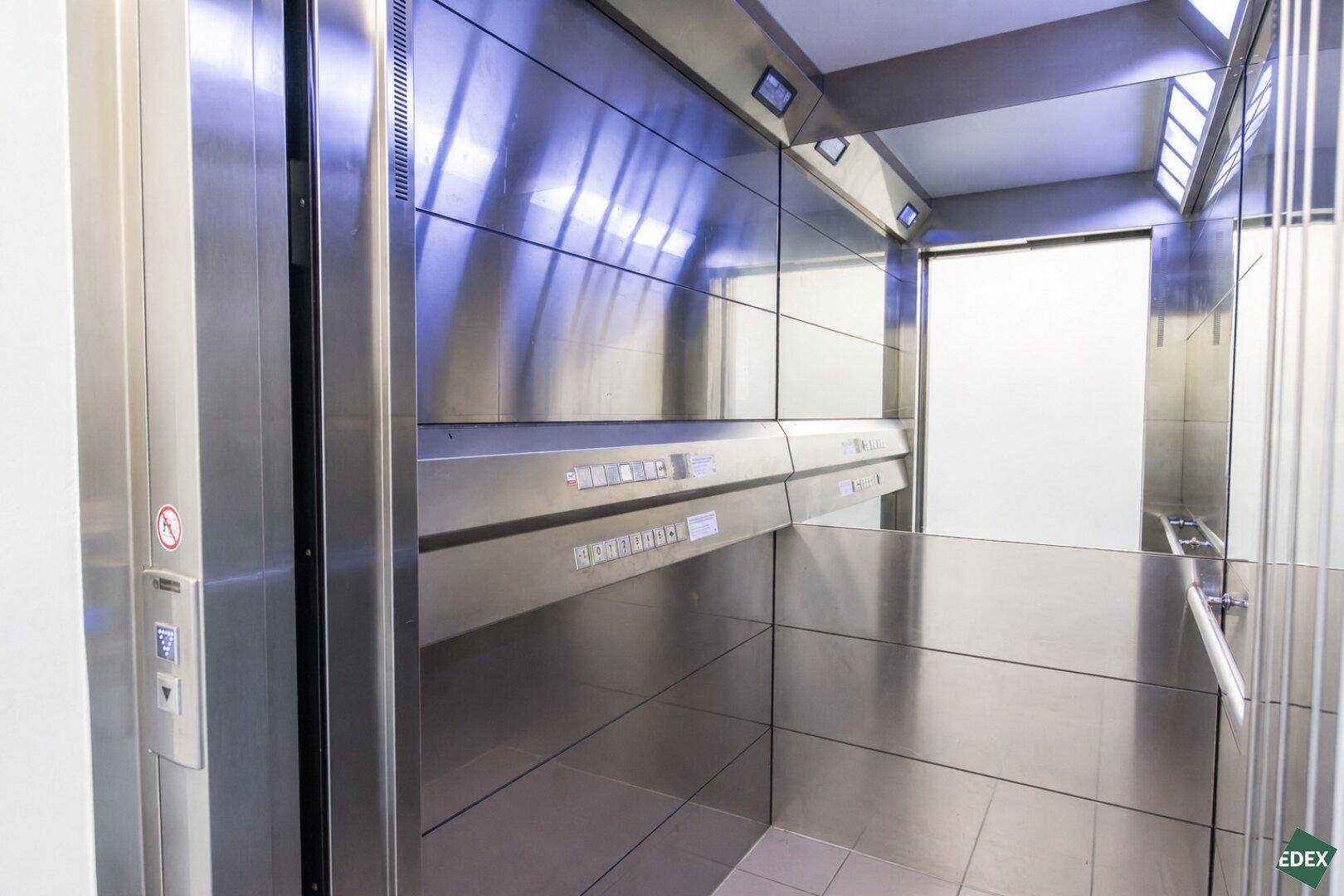 Moderner Aufzug mit Edelstahlverkleidung und Spiegelflächen, der die Etagen barrierefrei erschließt.