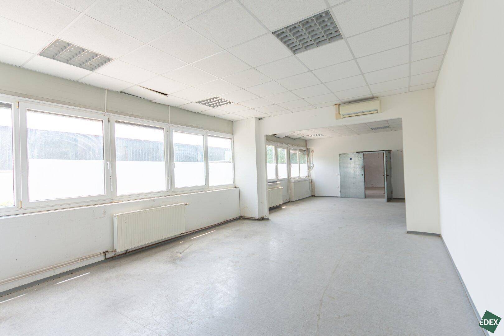 Großzügiger Bürobereich mit vielen Fenstern, Klimaanlage und abgehängter Decke.