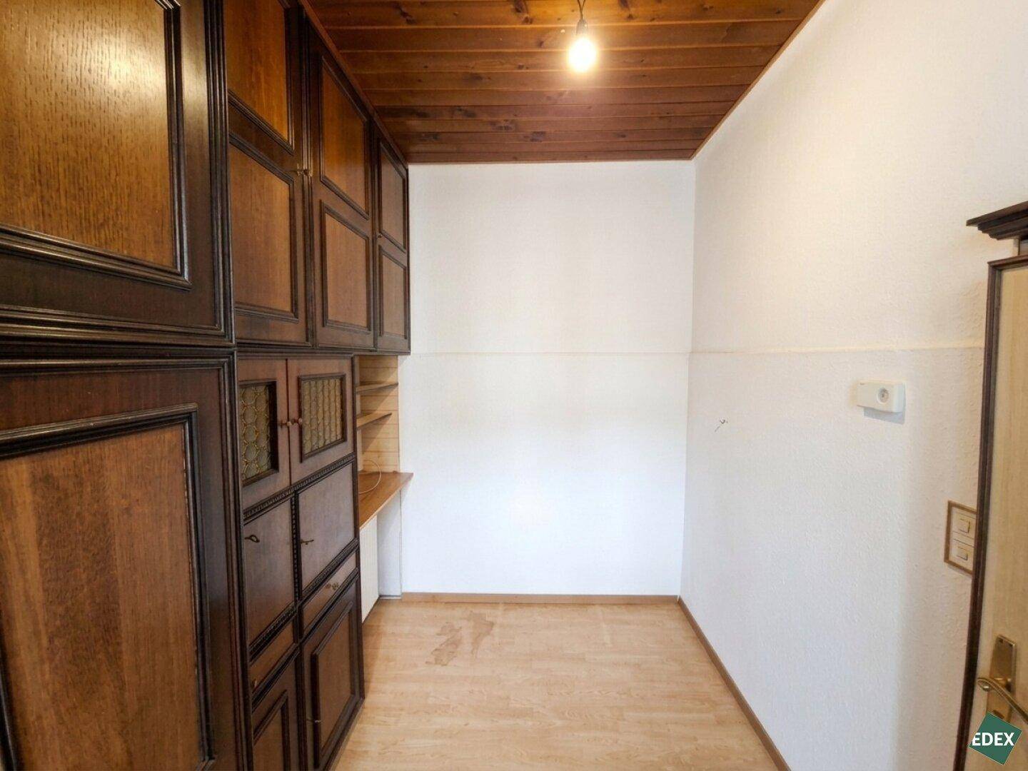 Kleiner Raum mit Holzboden und Einbauschränken, vielseitig nutzbar als Abstellraum oder Ankleidezimmer.