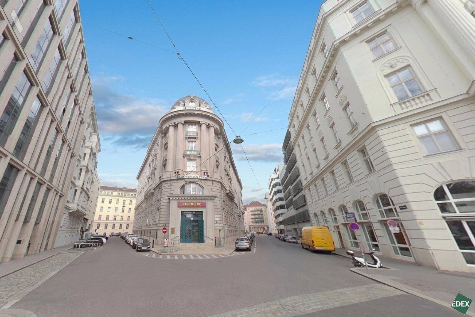 Historisches Eckgebäude mit beeindruckender Architektur an einer belebten Stadtstraße.