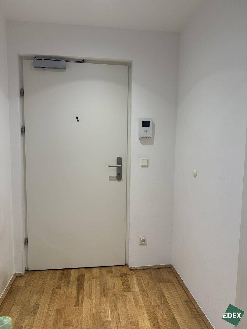 Eingangsbereich mit moderner Wohnungstür und Gegensprechanlage, bietet Sicherheit und Komfort.