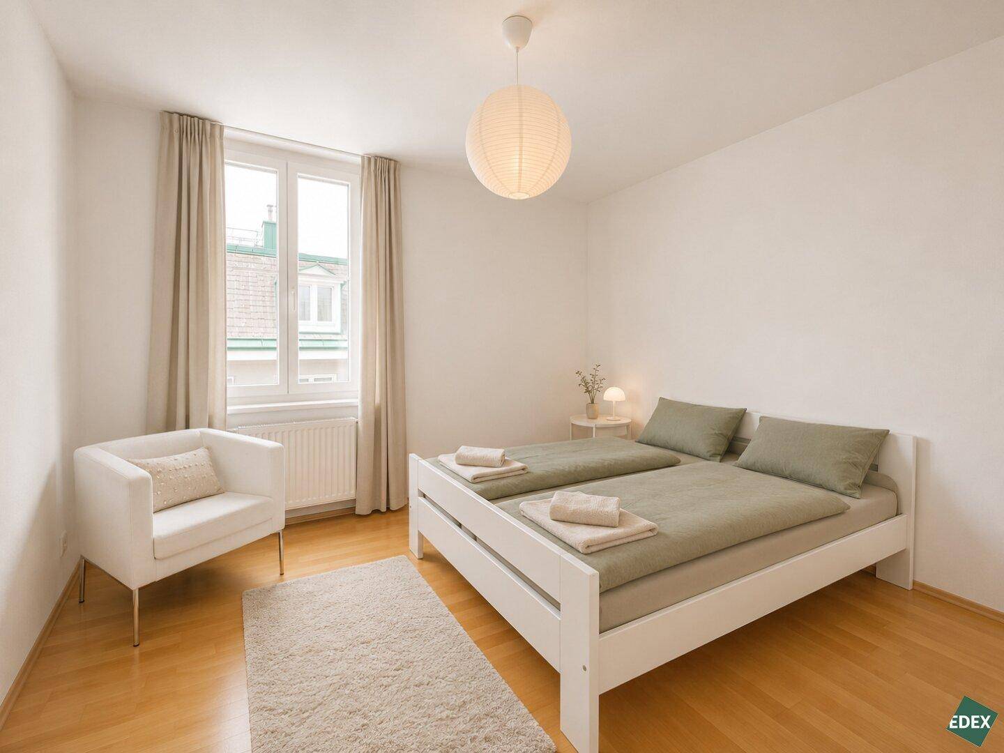 Freundliches Schlafzimmer mit hellem Holzbett, Teppich und einem Fenster für natürliche Belichtung.