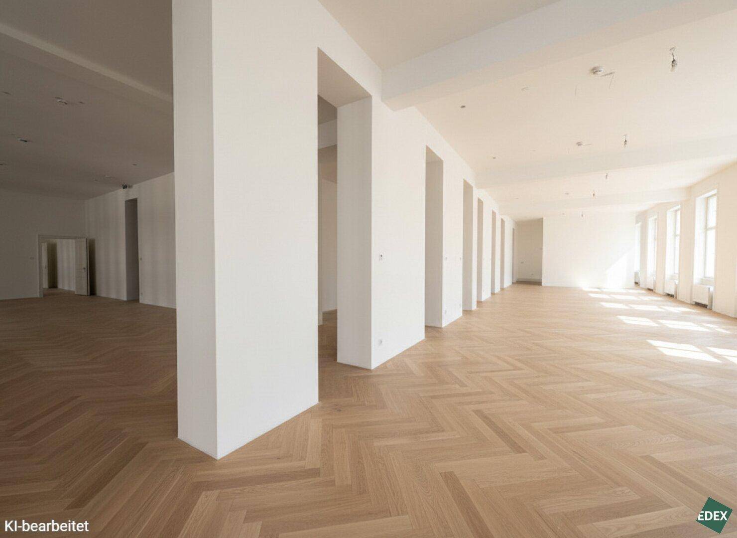 Heller, offener Raum mit elegantem Fischgrätparkett und hohen Decken, ideal für Büros.