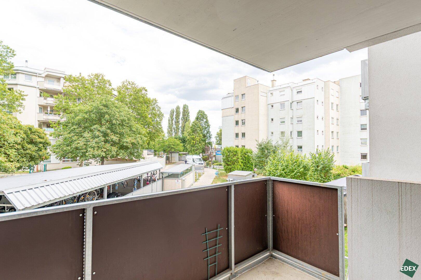 Balkon mit Blick auf die umliegenden Gebäude und viel Grün, ideal zum Entspannen.