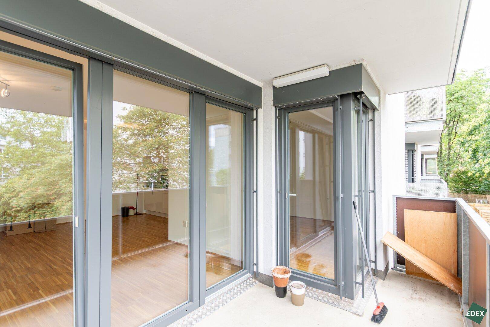 Geräumiger Balkon mit großen Fenstertüren, die viel Licht in die Innenräume lassen.