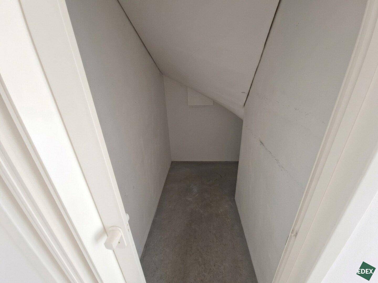Kleiner Abstellraum mit schrägen Wänden, ideal für zusätzlichen Stauraum.