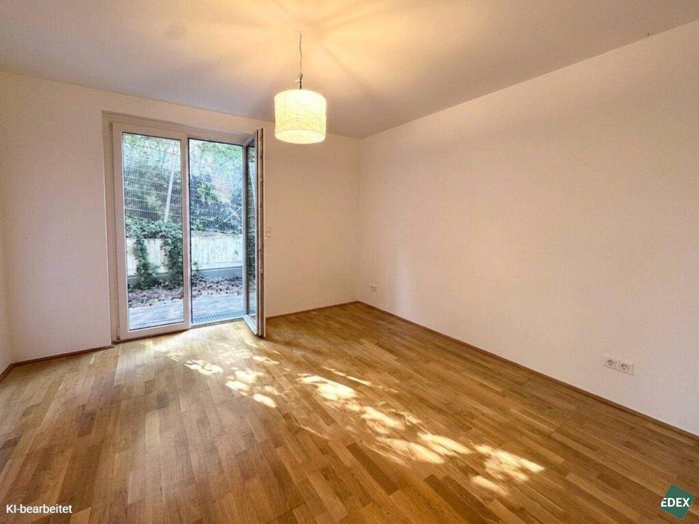 Ruhiges Zimmer mit Holzboden und Zugang zum Außenbereich, ideal als Schlafzimmer oder Arbeitszimmer.