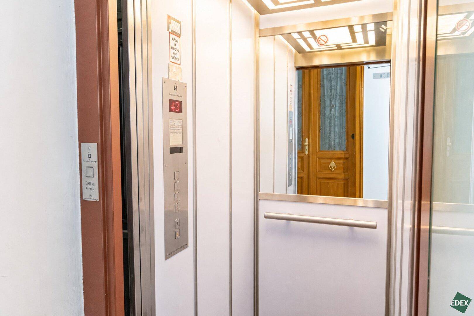 Moderner Aufzug mit Spiegel und Bedienfeld, der Zugang zu den Etagen bietet.