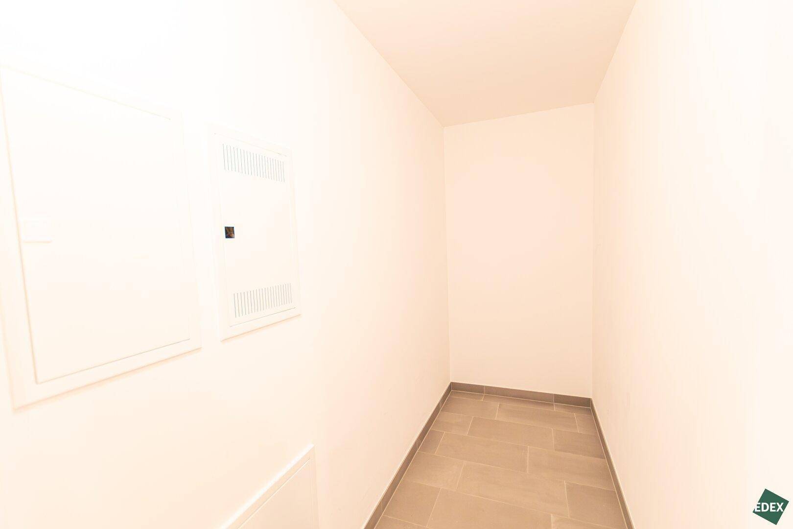 Praktischer Abstellraum mit Fliesenboden und Zugang zu den technischen Installationen des Hauses.