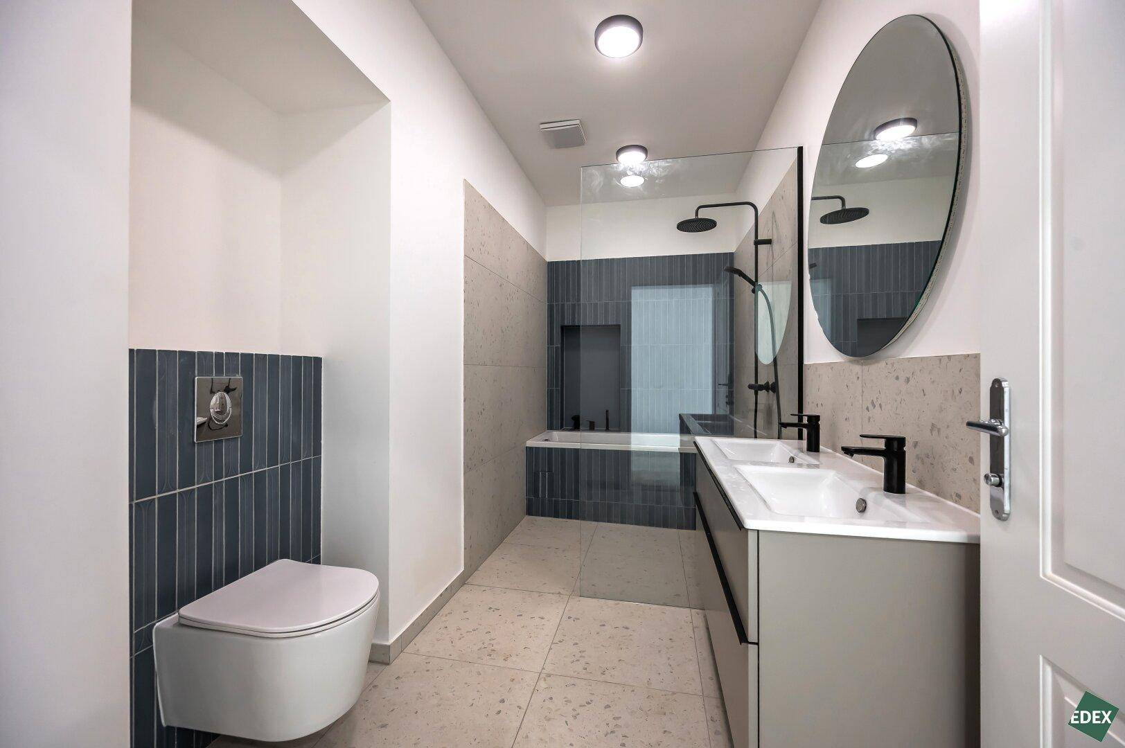 Modernes Badezimmer mit Doppelwaschbecken, Badewanne und separater Dusche.