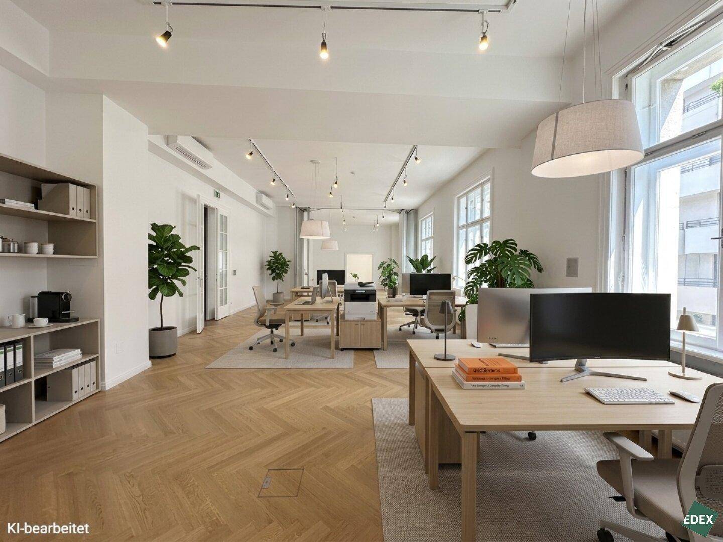 Moderne, offene Bürofläche mit mehreren Arbeitsplätzen, Holzparkett und großen Fenstern, die viel Tageslicht hereinlassen.