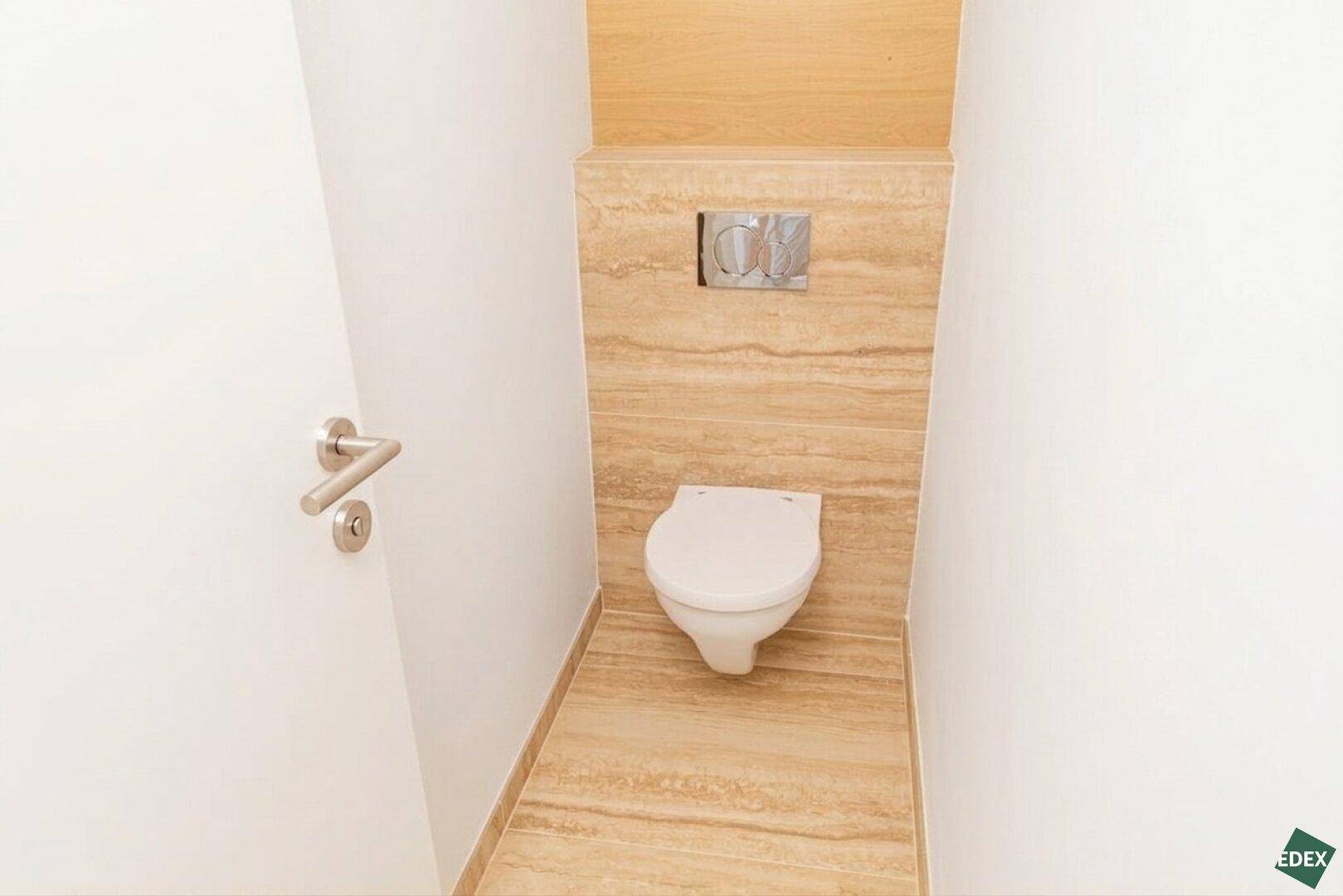 Modernes Gäste-WC mit Wand-WC und eleganten Fliesen an Wand und Boden.
