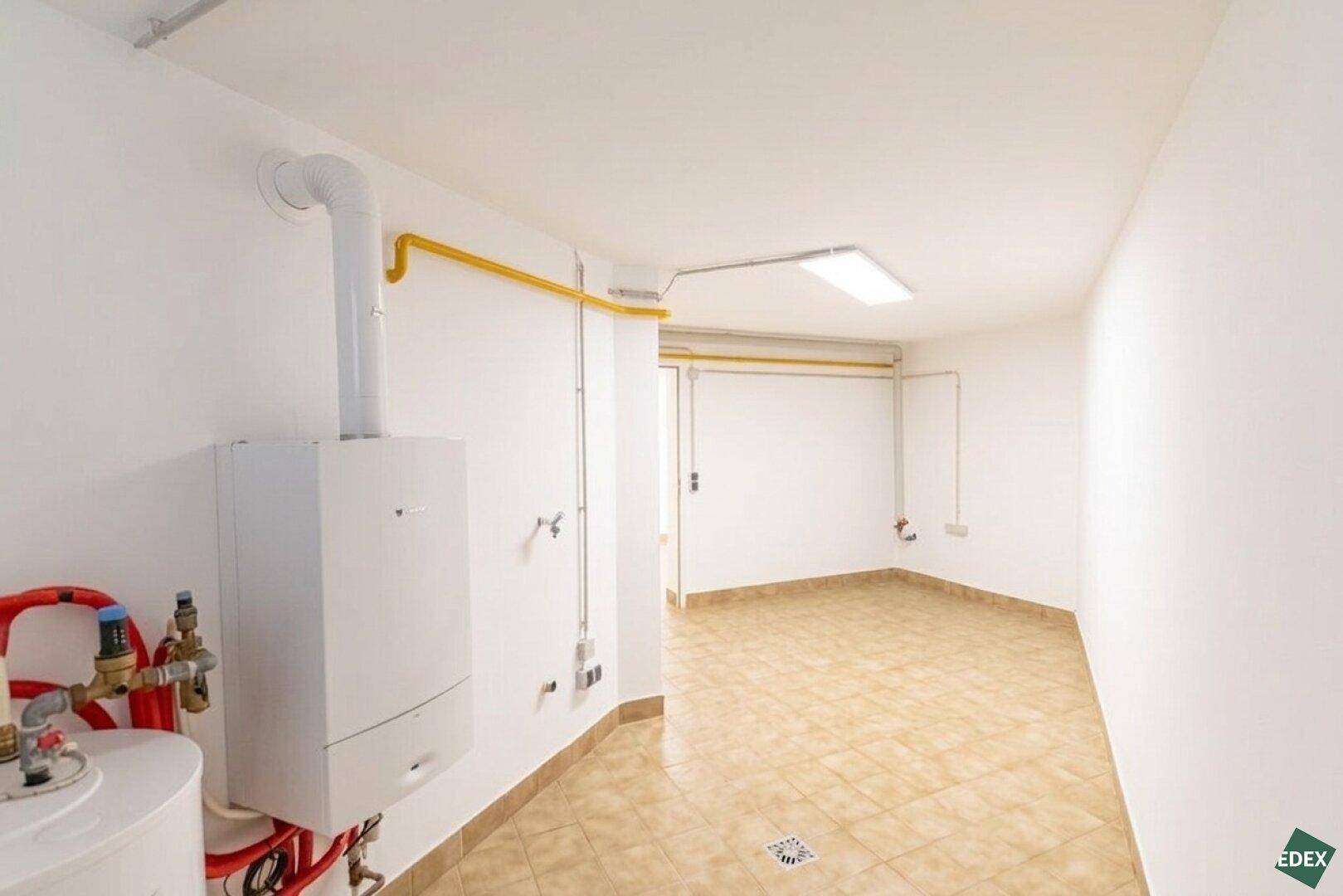 Funktionaler Hauswirtschaftsraum im Keller mit Heizungsanlage und Fliesenboden.