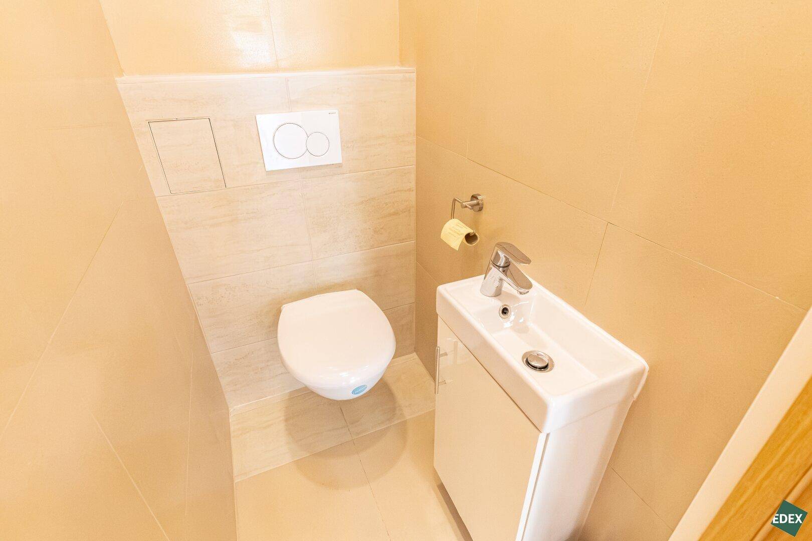 Kleines Gäste-WC mit Wand-WC und modernem Waschbecken.