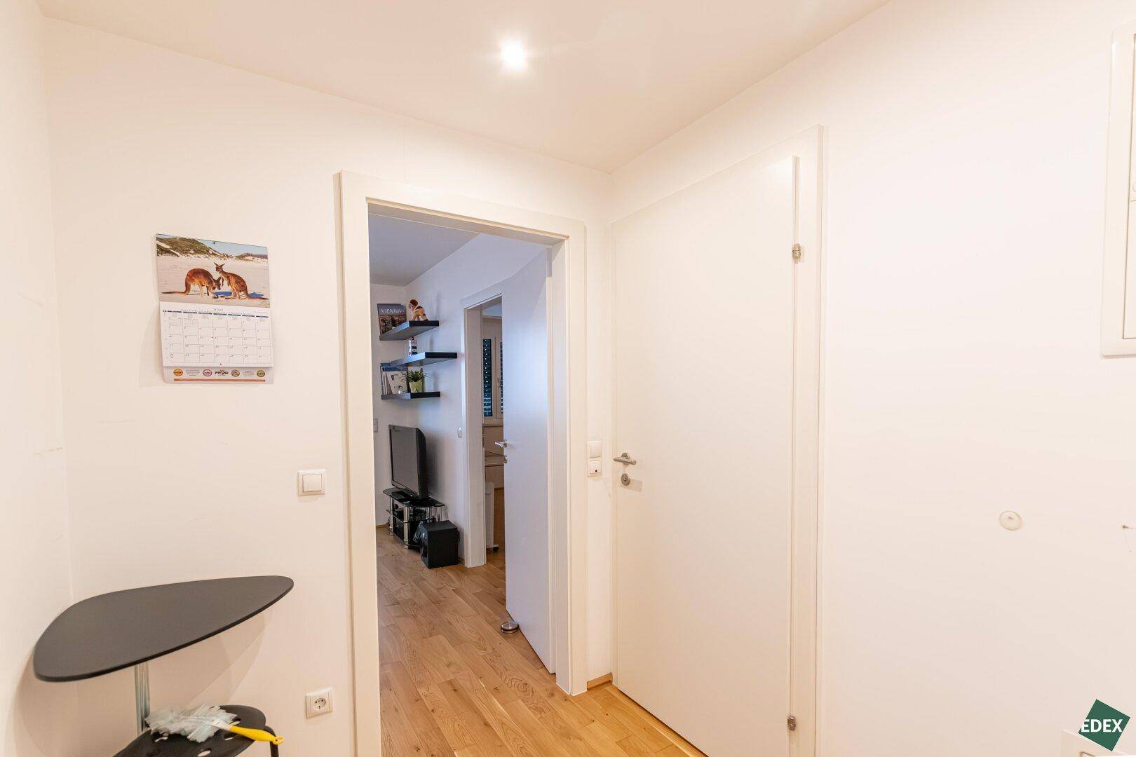 Heller Flur mit Parkettboden, der zu den weiteren Räumen der Wohnung führt.
