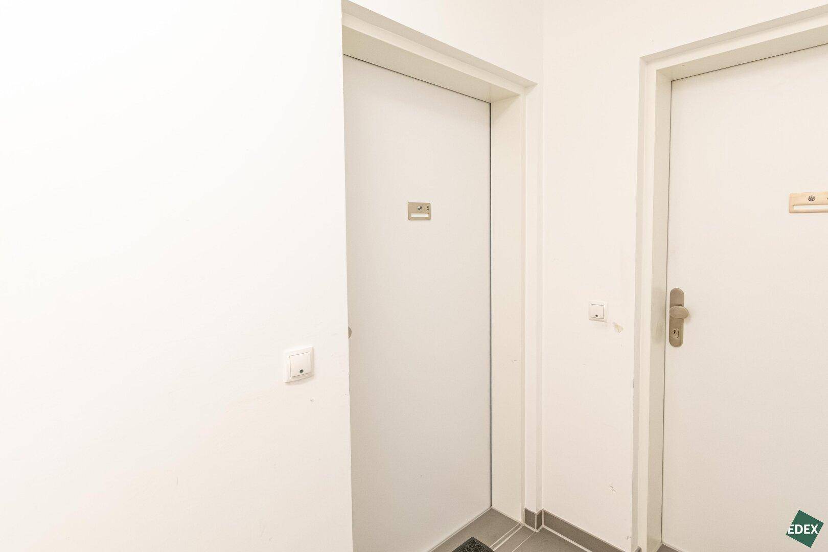 Heller Flur mit zwei Türen, die zu verschiedenen Räumen der Wohnung führen.