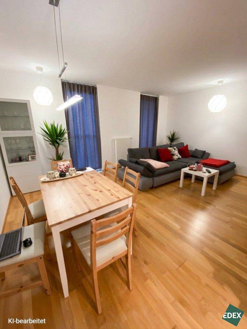 Geräumiger Wohn-Essbereich mit Holztisch, bequemer Couch und hellem Parkettboden für entspannte Stunden.