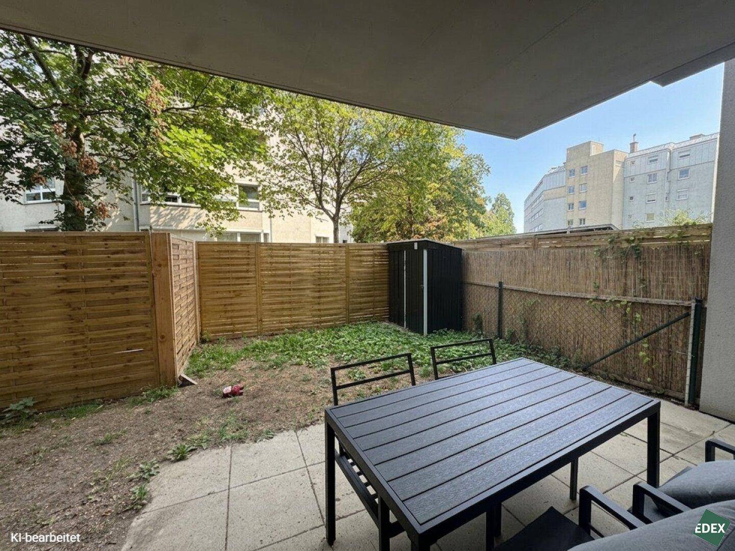 Kleiner privater Gartenbereich mit Terrasse, Gartenmöbeln und einem Geräteschuppen.