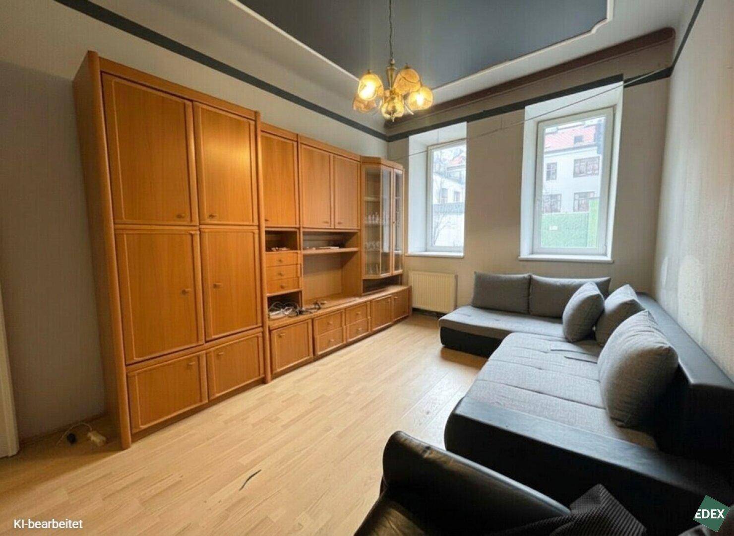 Gemütliches Wohnzimmer mit großer Holzschrankwand, Ecksofa und klassischem Kronleuchter.