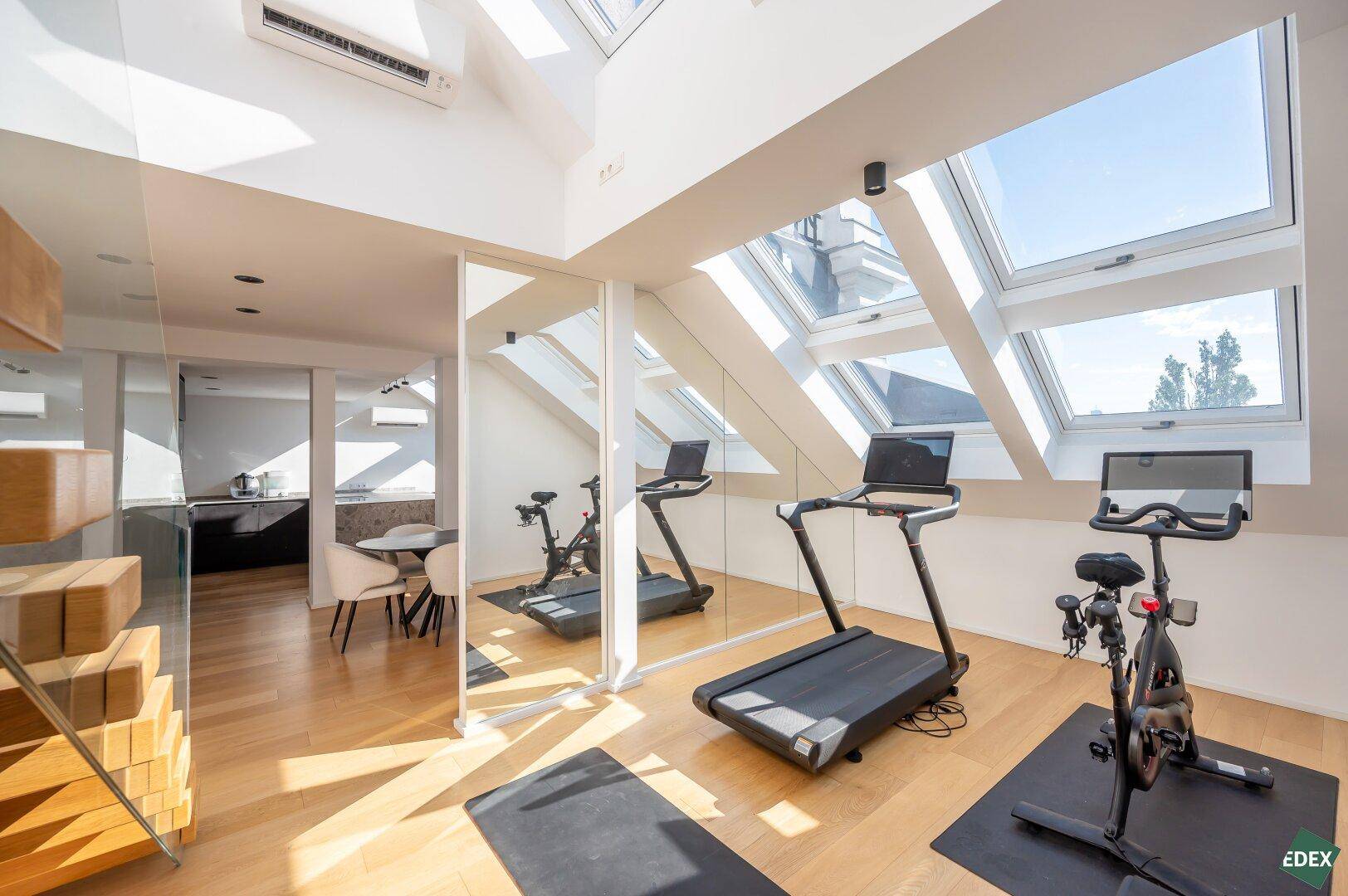 Heller Fitnessbereich mit Laufband und Fahrrad, ideal für das Heimtraining.